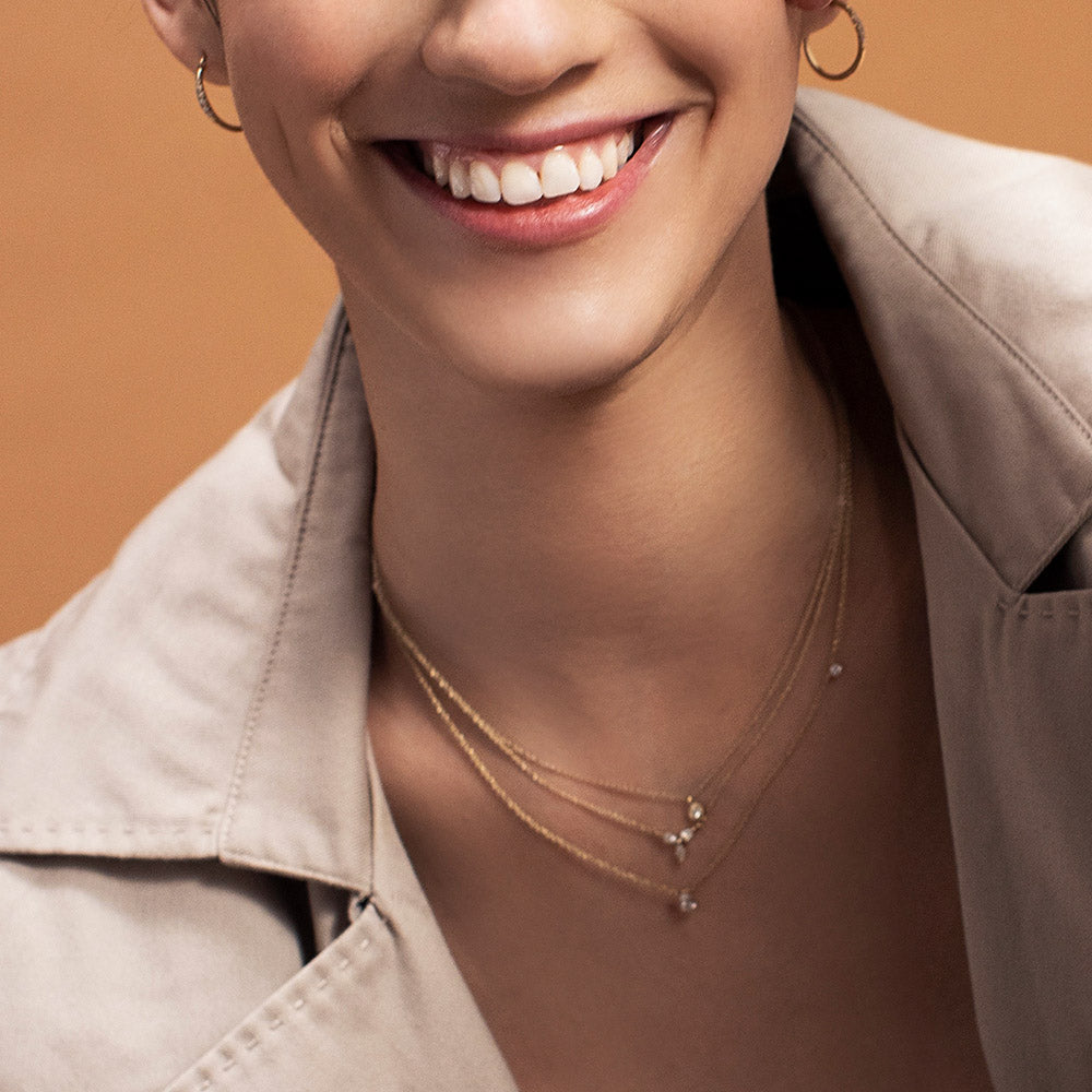 A gold chain set with a drop-cut diamond and a round diamond on the side