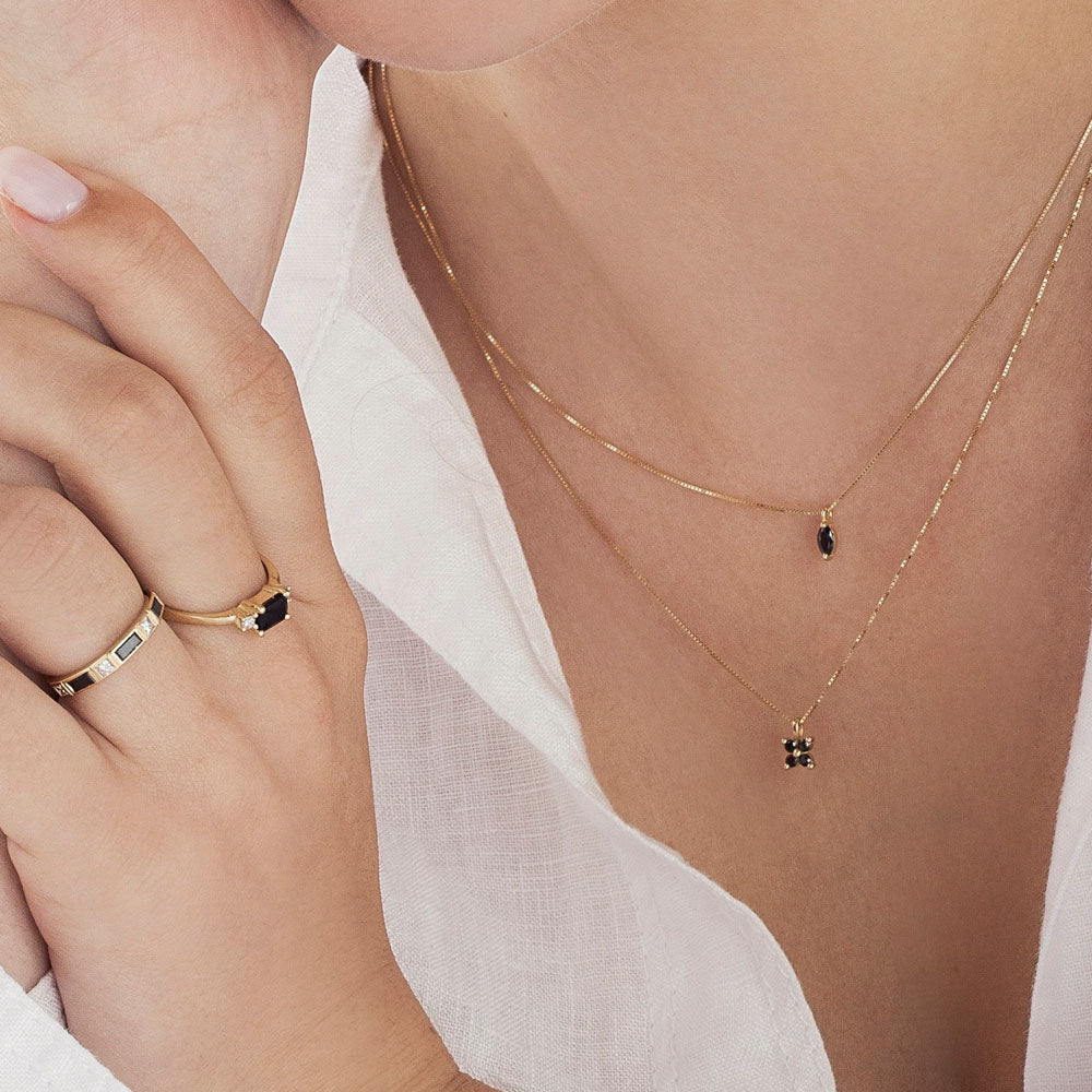 Delicate gold necklace for women with 4 black diamonds in the shape of a horizontal flower