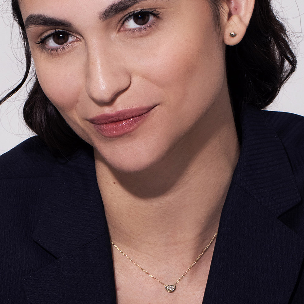 A special gold chain set with a diamond in a semi-circle cut in a modern design