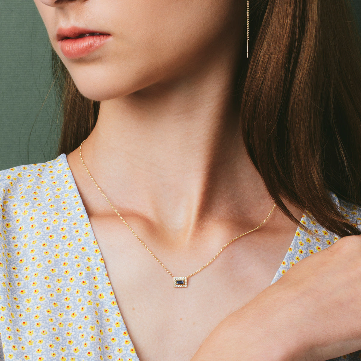 A baguette cut gold chain studded with diamonds and sapphires