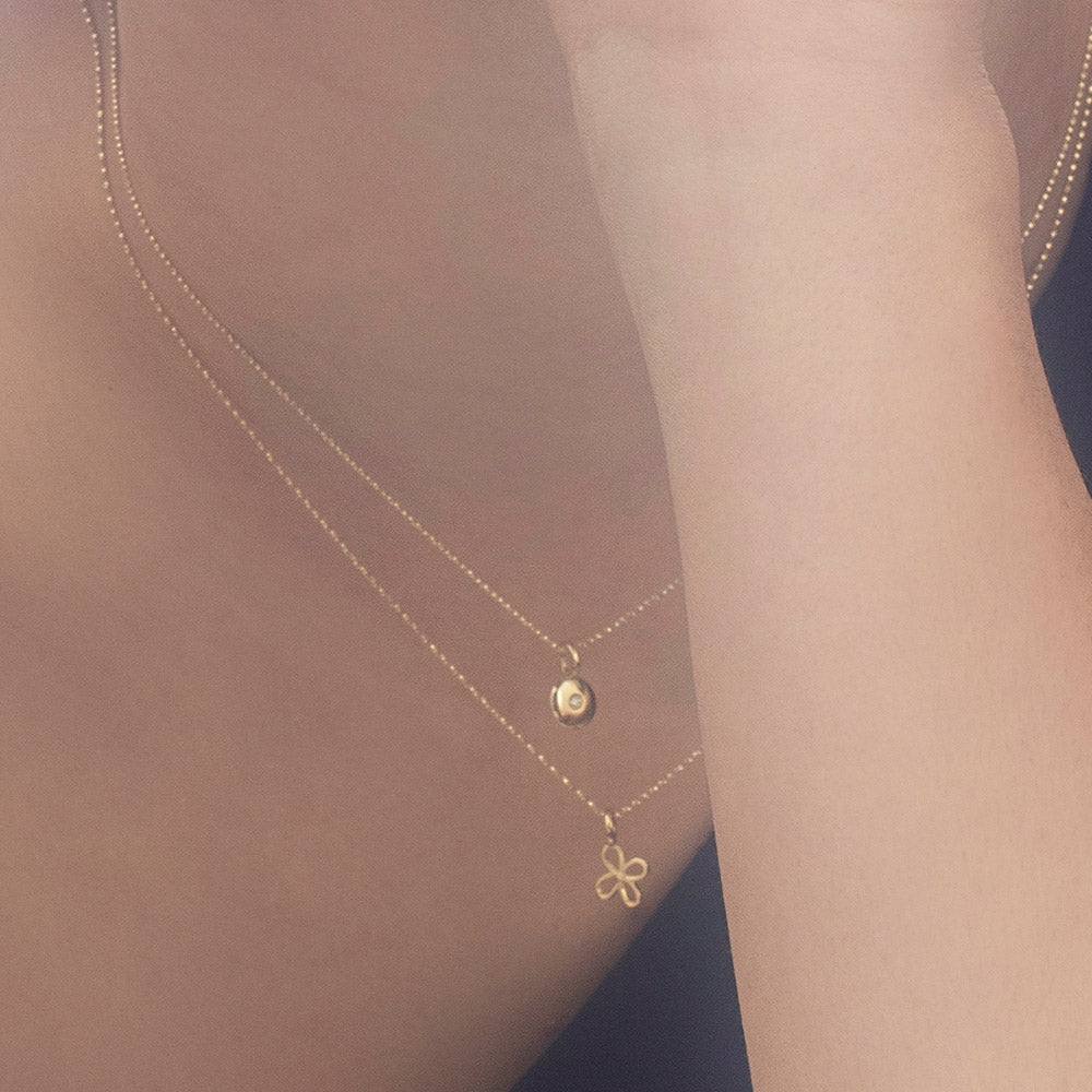 A fine gold chain with a pendant in the shape of a flower