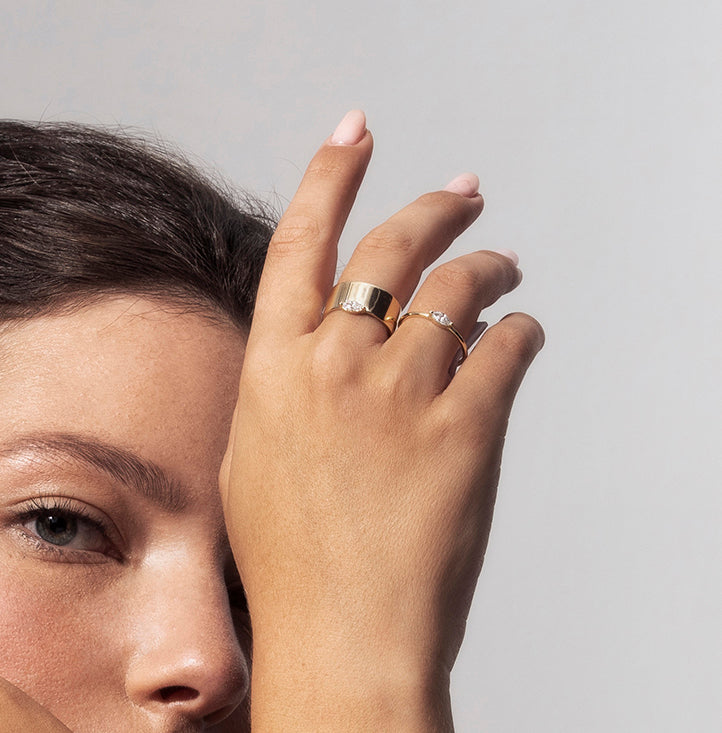A wide gold ring set with a marquise-cut diamond