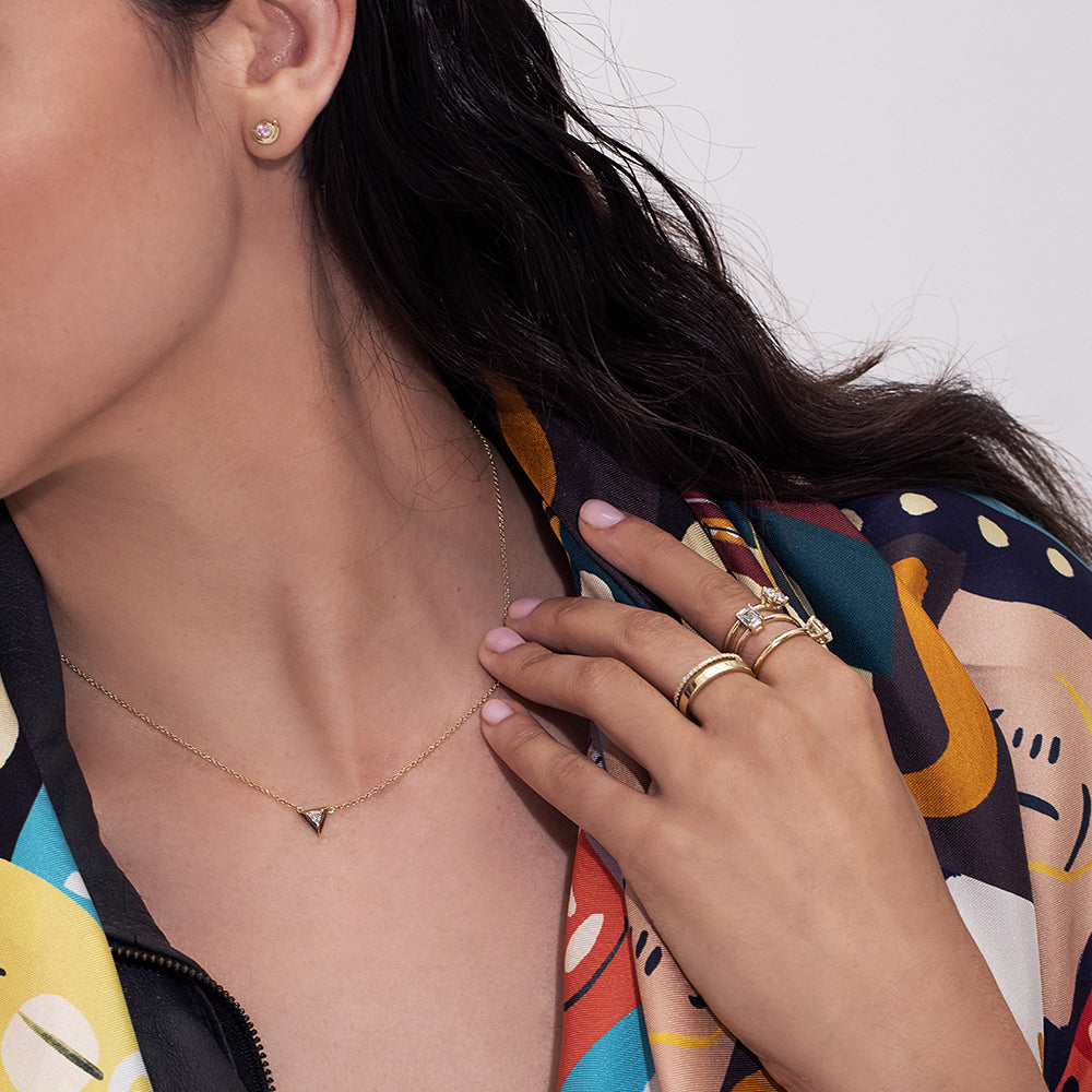 Gold earrings, tight, small, in the shape of a semicircle embedded with a pink sapphire
