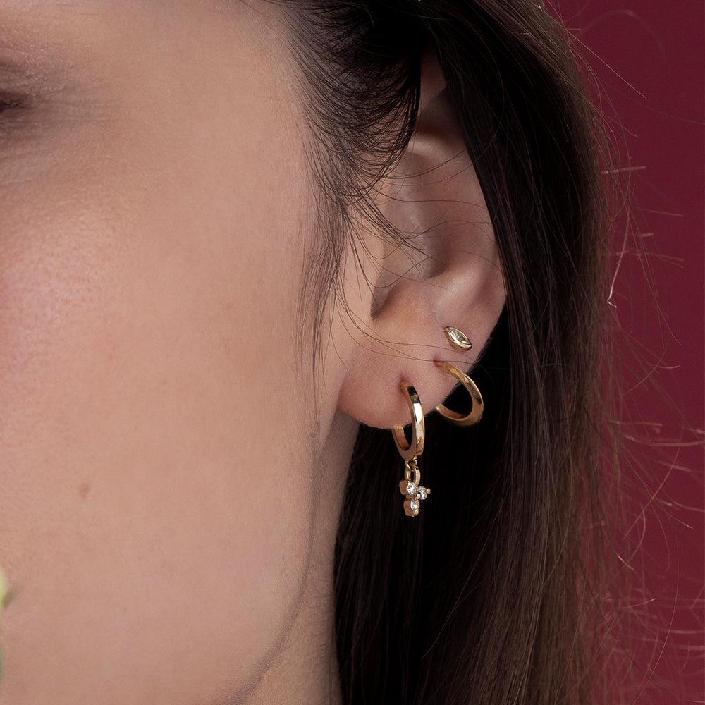 Gold hoop earrings with a triangular pendant with 3 white diamonds