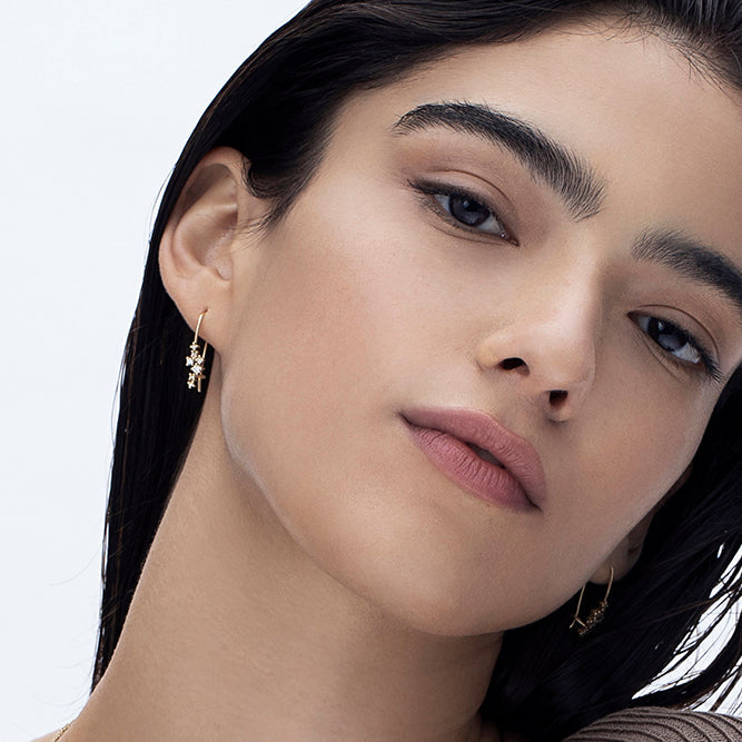 Hanging gold earrings studded with diamonds of varying sizes