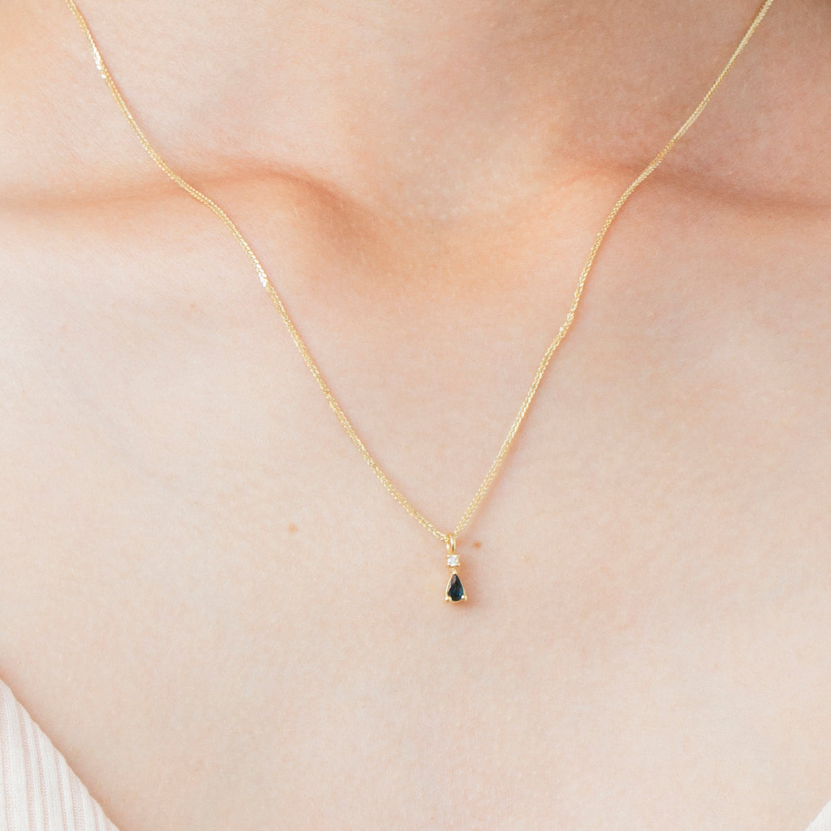 Gold necklace with a drop sapphire and diamond inlaid pendant