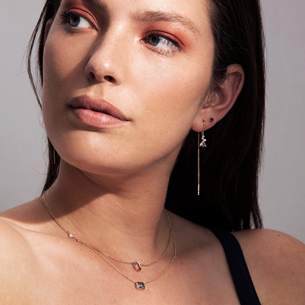 Gold earrings with a chain set with trillion-cut morganite and small diamonds of varying sizes