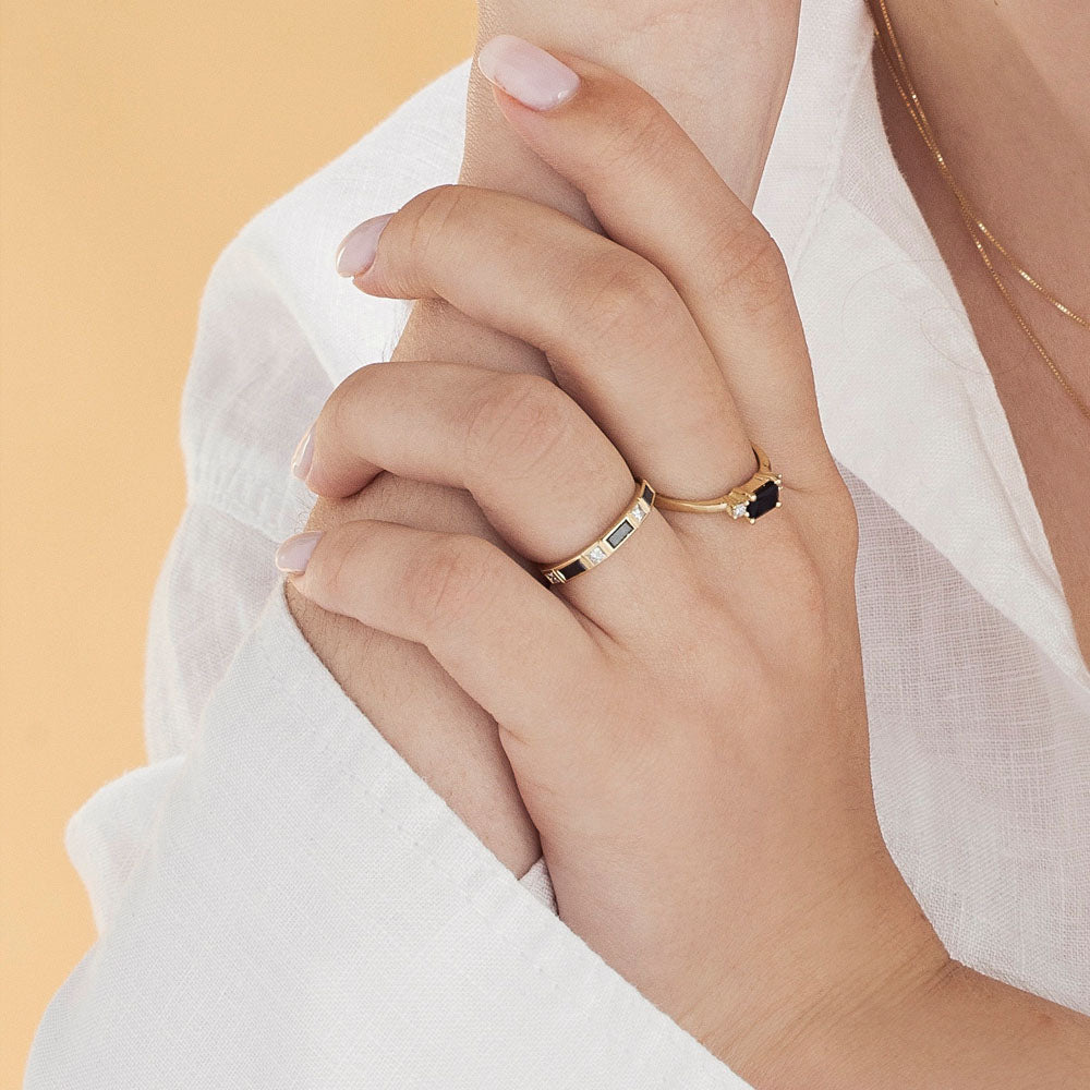 A semi-eternity ring set with baguette-cut black diamonds and princess-cut white diamonds