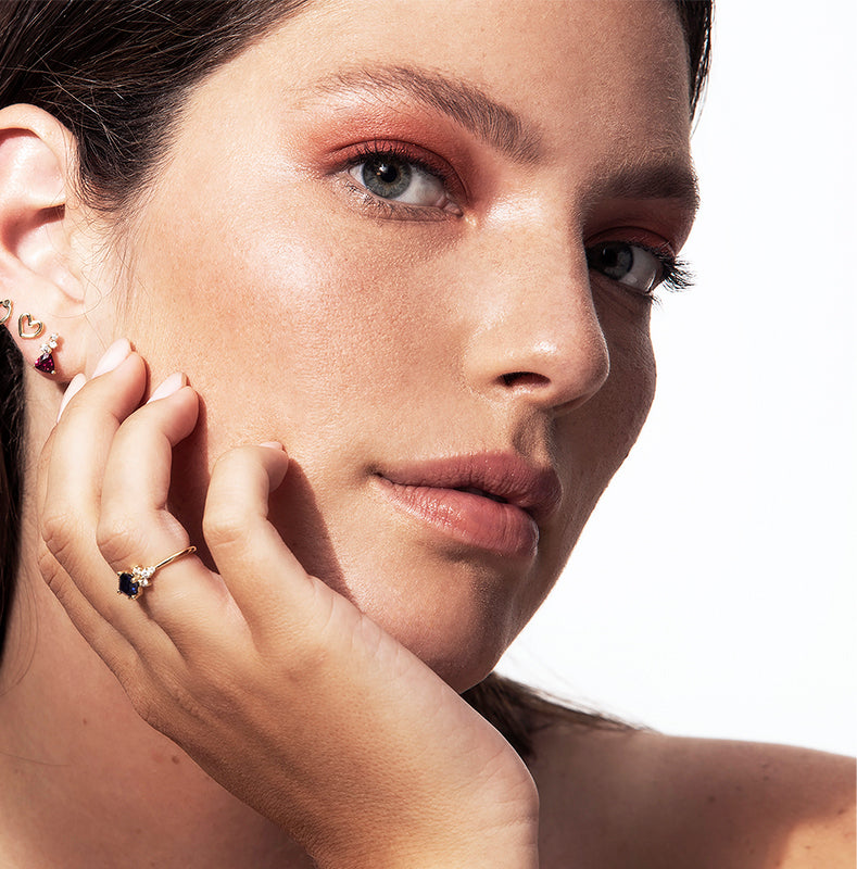 A gold ring set with princess tanzanite and round diamonds