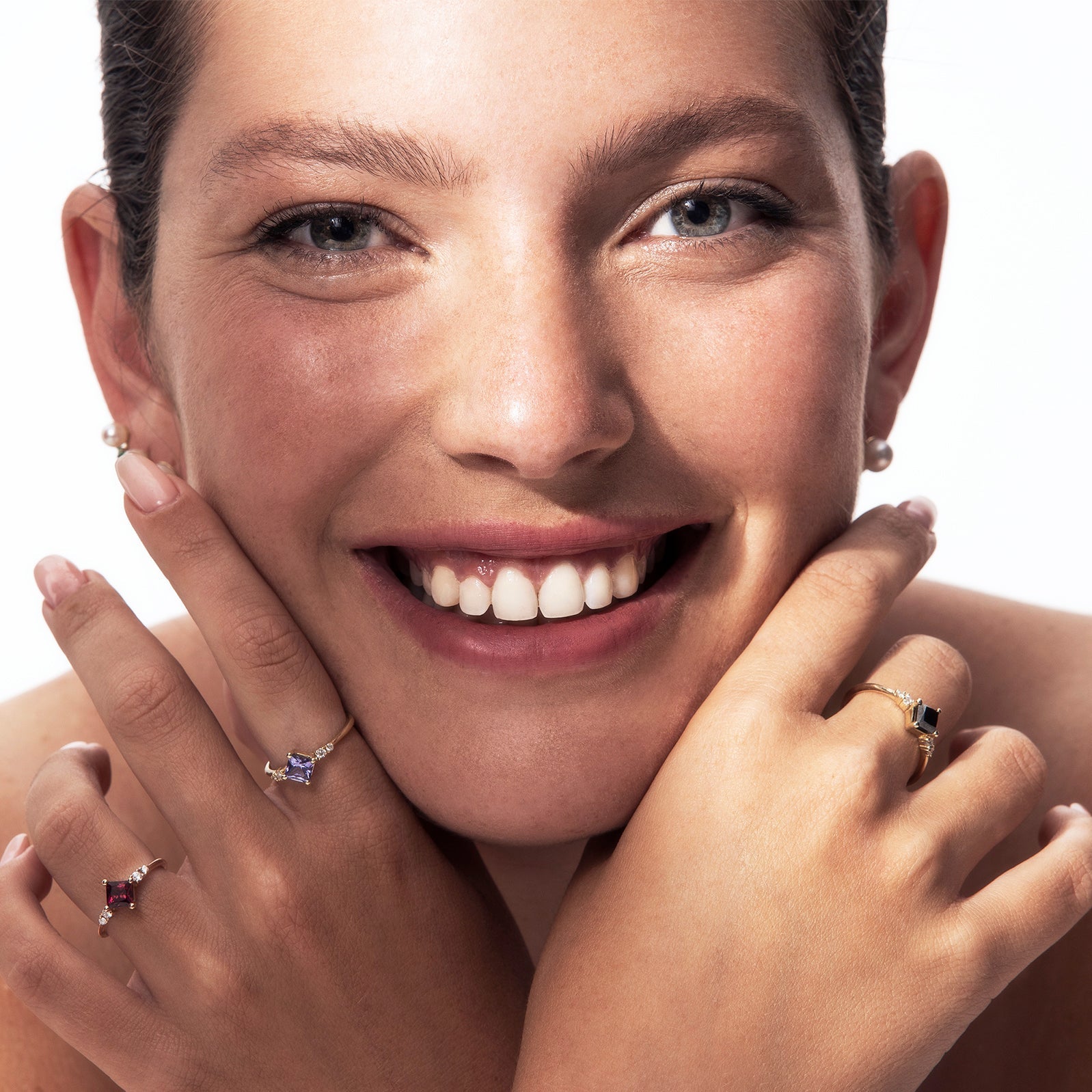 A gold ring set with princess-cut tanzanite and diamonds on the sides