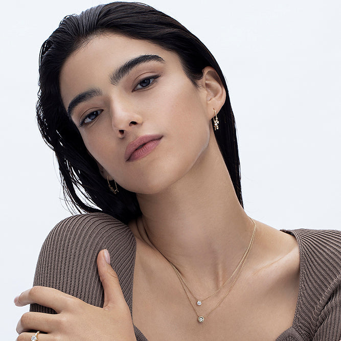 Hanging gold earrings studded with laboratory diamonds of varying sizes