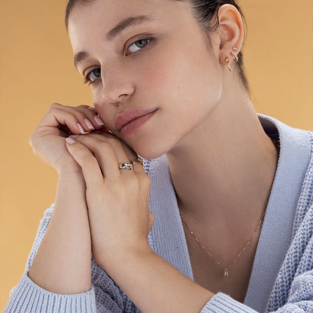 A wide gold ring with a special asymmetric setting of tanzanite, sapphire and diamonds
