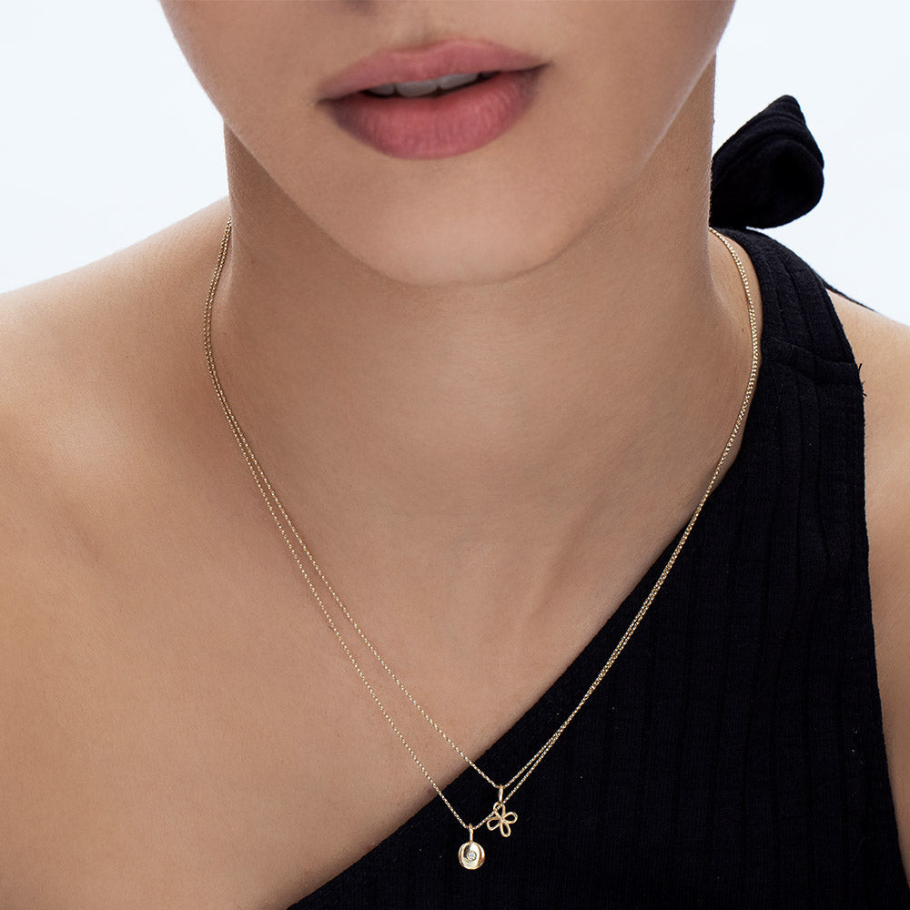 A fine gold chain with a pendant in the shape of a flower