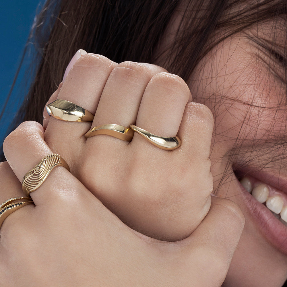 A thick geometric wave-shaped gold ring