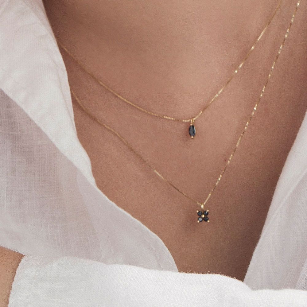 Delicate gold necklace for women with 4 black diamonds in the shape of a horizontal flower