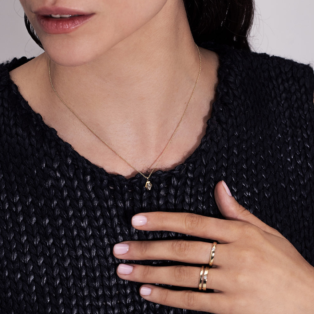 A gold ring set with a round diamond weighing 5 points