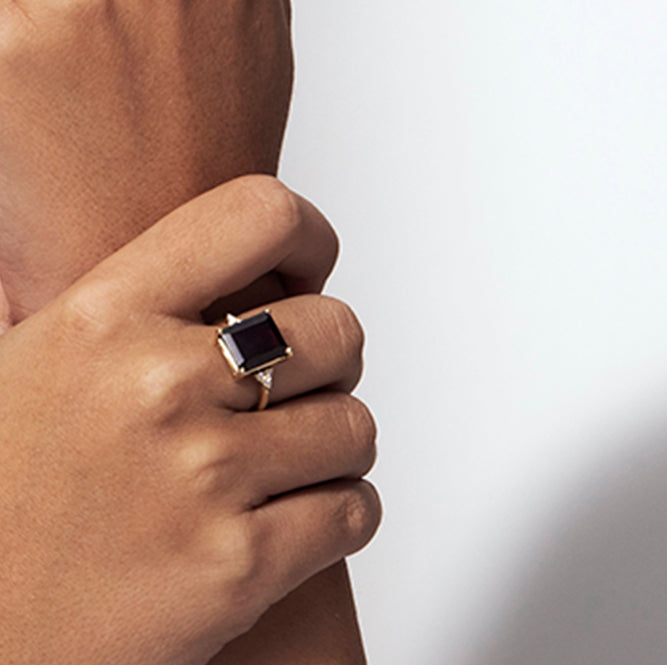 An engagement ring set with a rectangular garnet and 6 sided diamonds