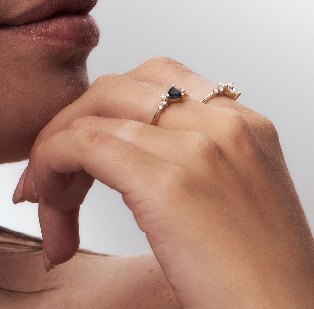 An engagement ring set with a trillion-cut sapphire and diamonds all around