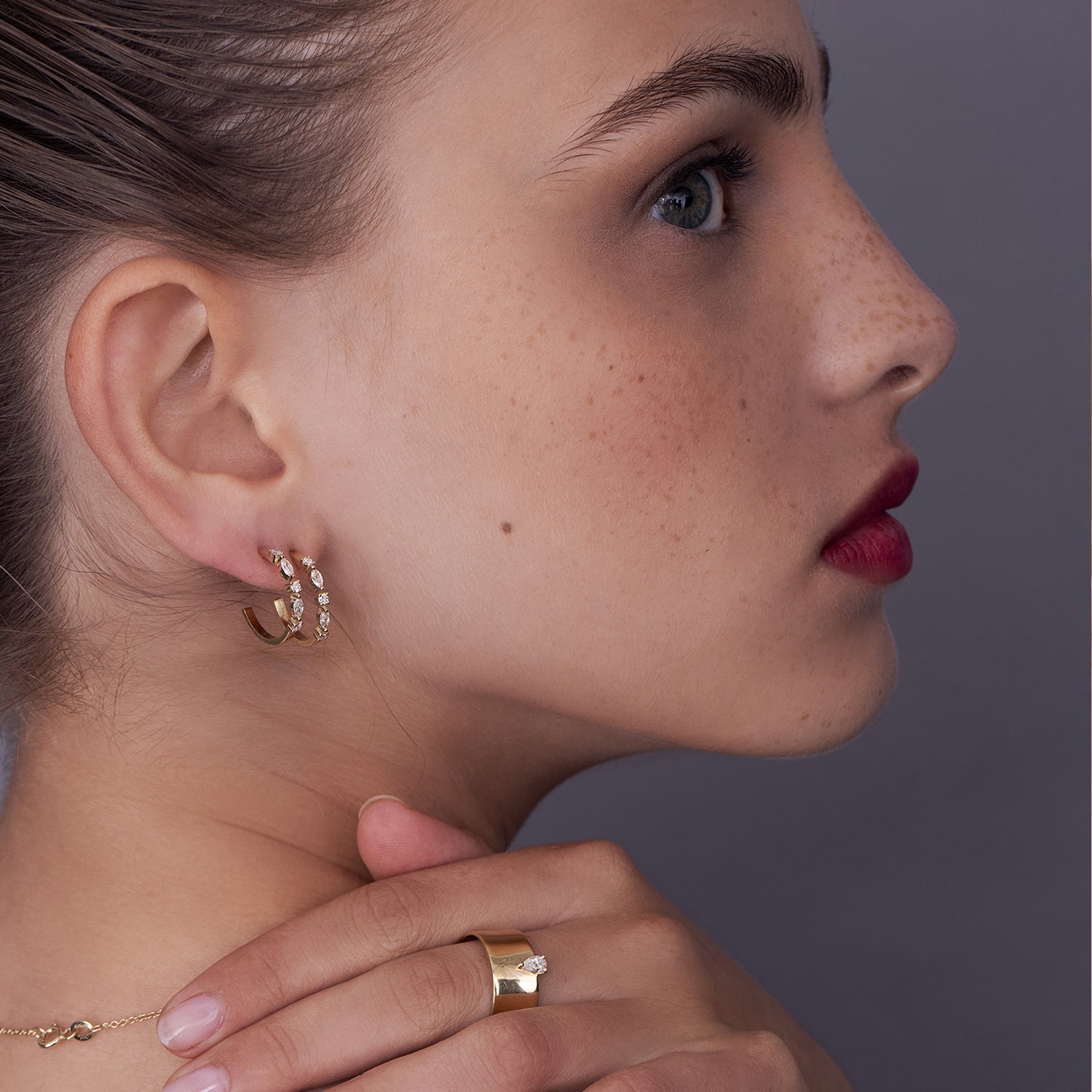A wide gold ring set with a drop cut diamond