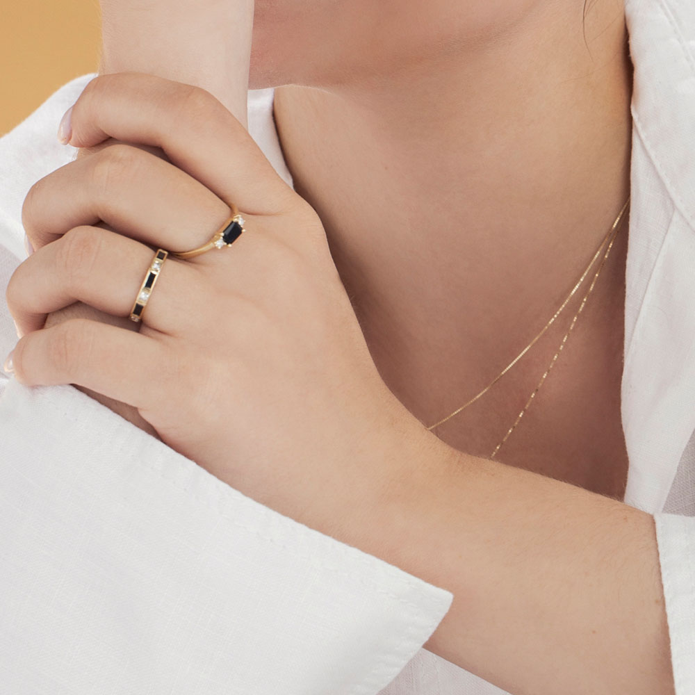 A semi-eternity ring set with baguette-cut black diamonds and princess-cut white diamonds