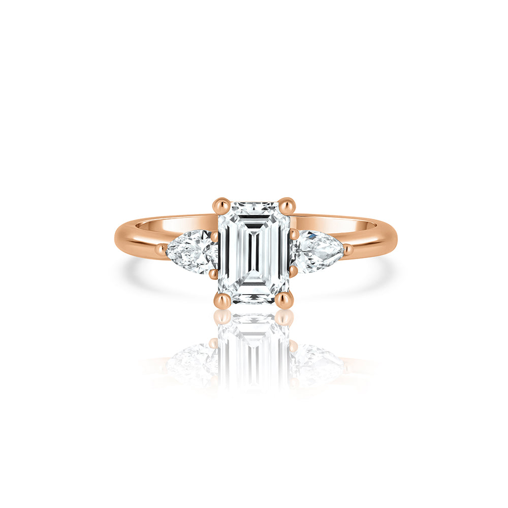 An engagement ring set with laboratory diamonds. Emerald cut central diamond and two drops