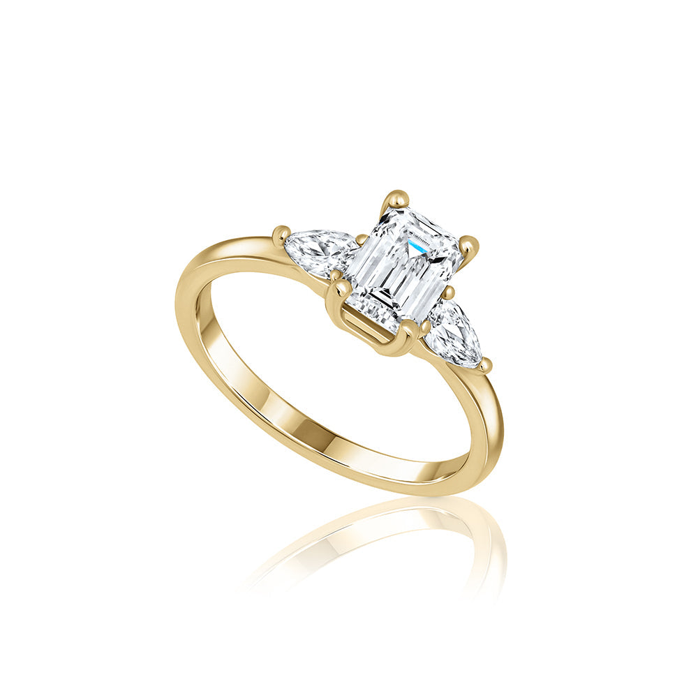 An engagement ring set with laboratory diamonds. Emerald cut central diamond and two drops