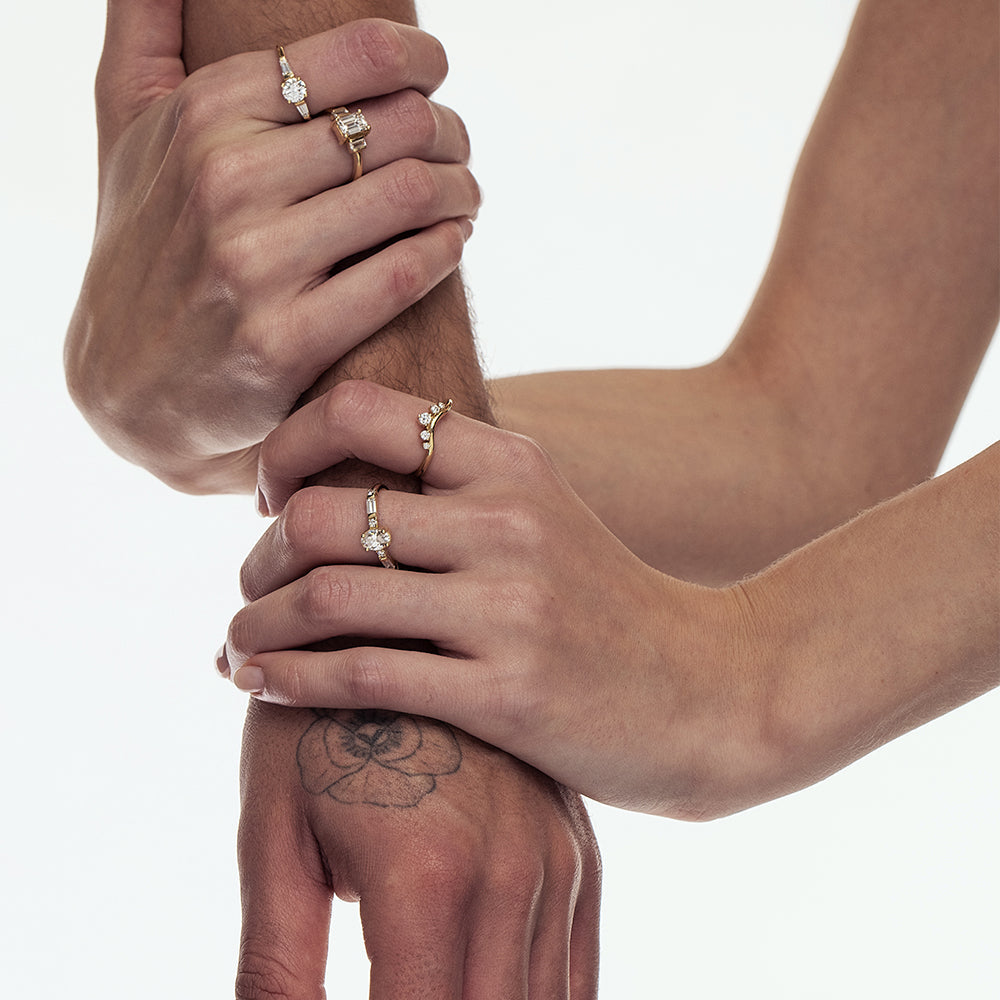 A gold ring in the shape of a wave, a crown set with 5 laboratory diamonds of varying sizes.