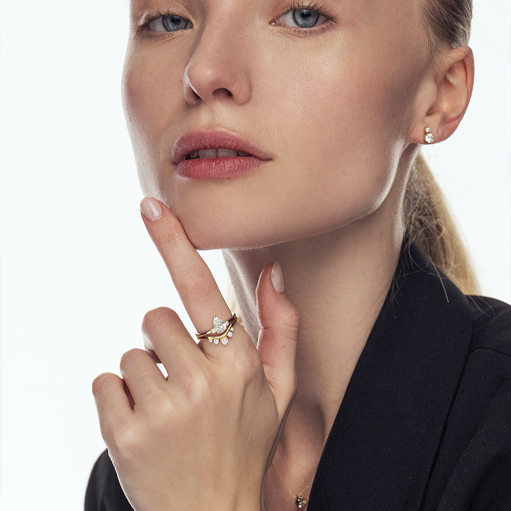 A gold ring in the shape of a wave, a crown set with 5 laboratory diamonds of varying sizes.