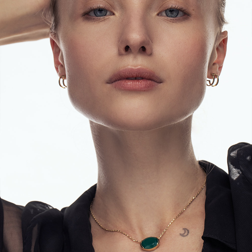 A gold chain inlaid with a green onyx stone, impressive in an oval cut