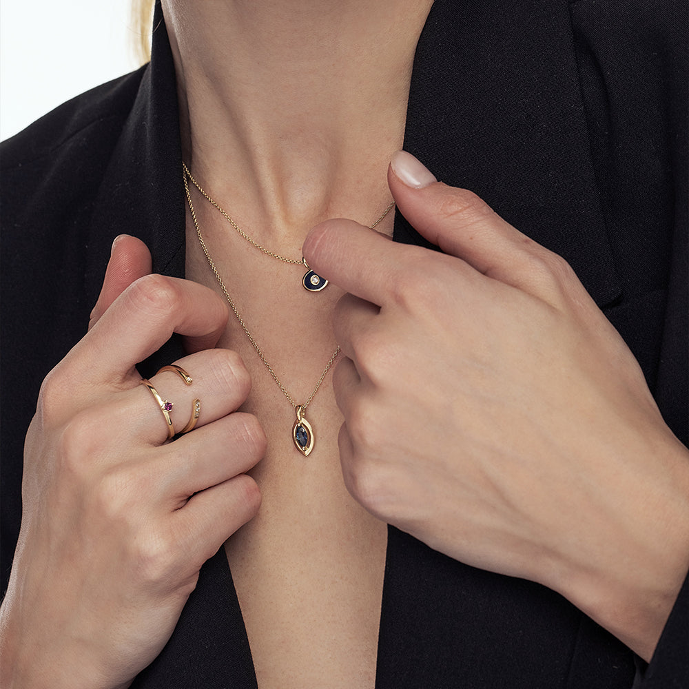 A gold chain with a modern evil eye pendant for men, inlaid with a marquise-cut sapphire