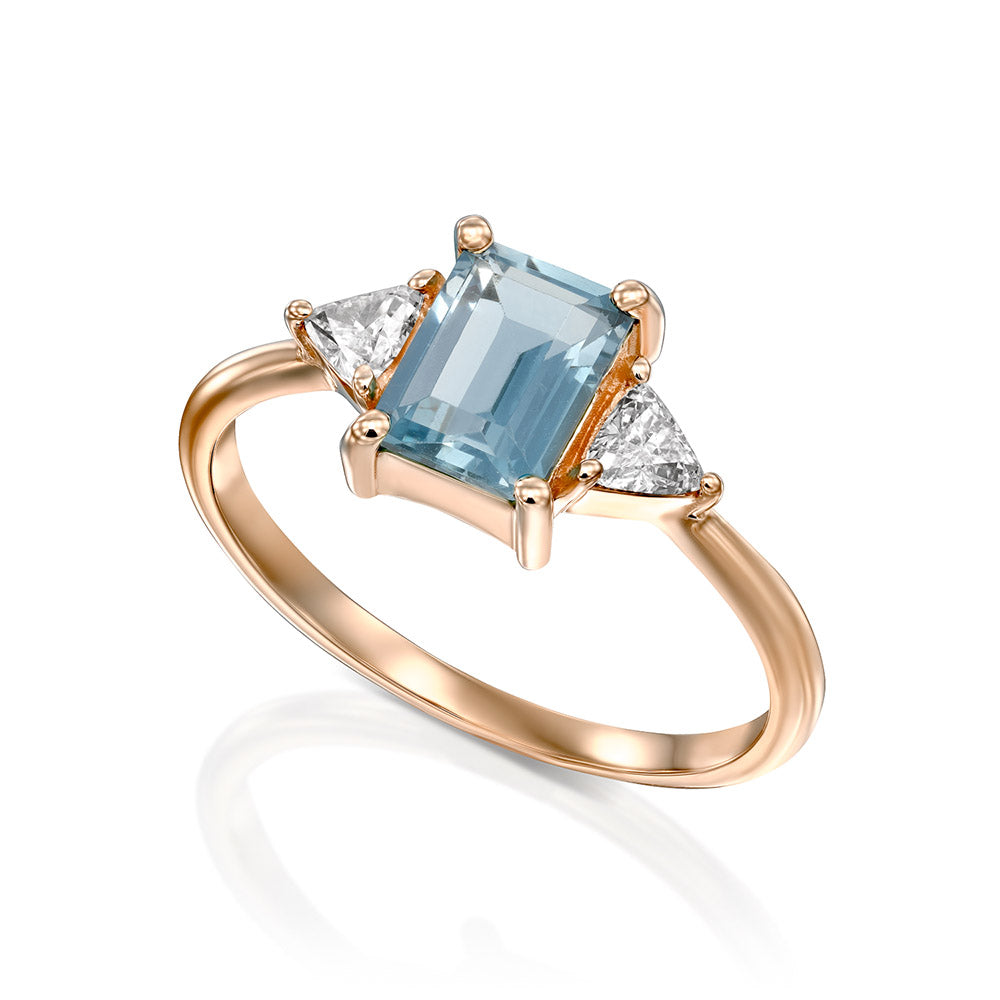 Gold ring set with light London blue topaz and trillion-cut diamonds on the sides