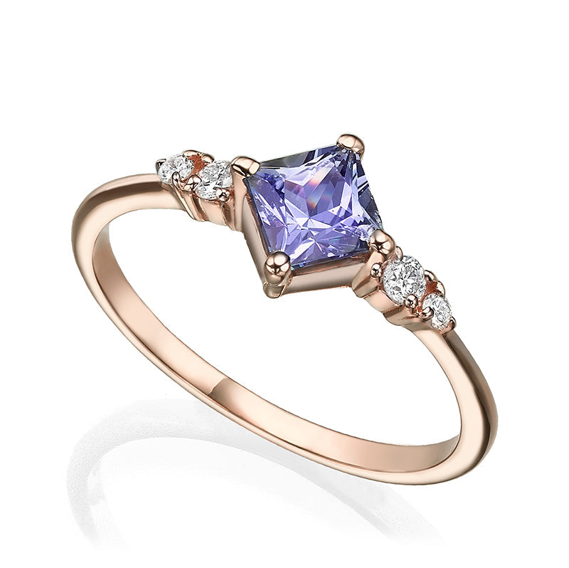 A gold ring set with princess-cut tanzanite and diamonds on the sides