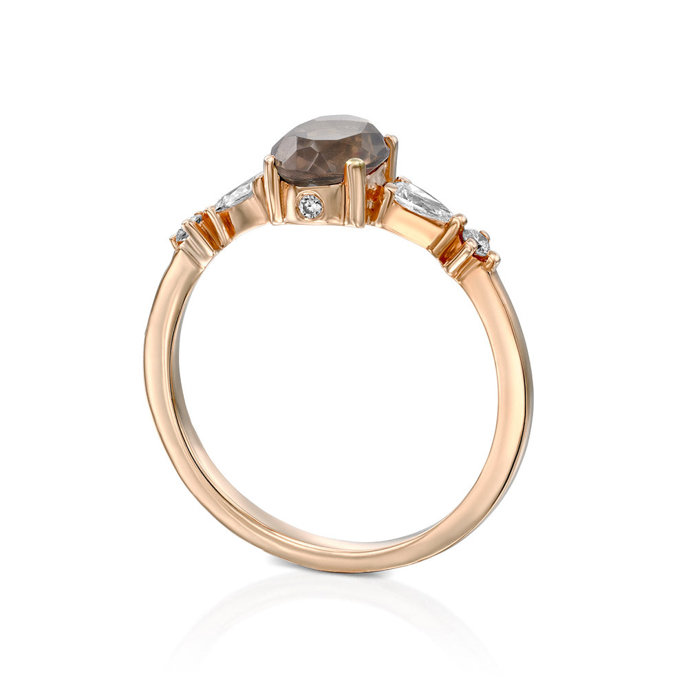 A gold ring set with smoky quartz and drop and round cut diamonds