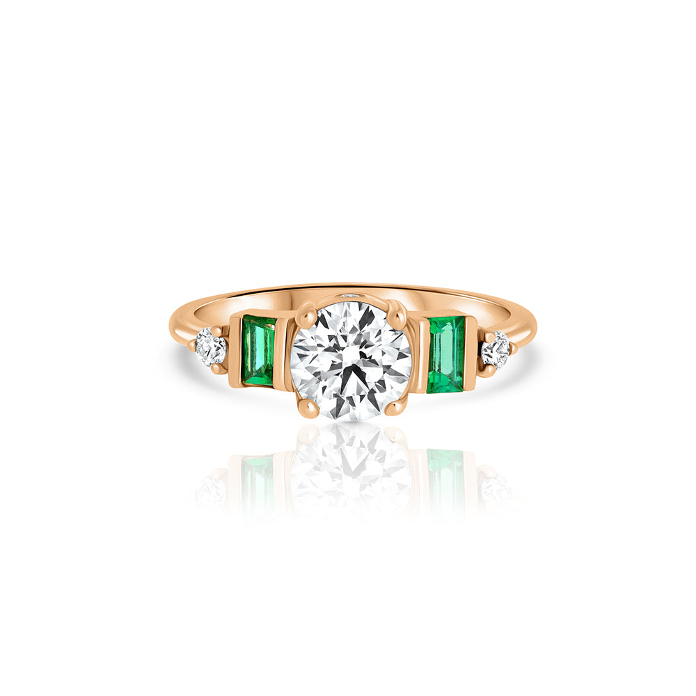 An engagement ring in gold and laboratory diamonds in a unique design of round diamonds and emeralds