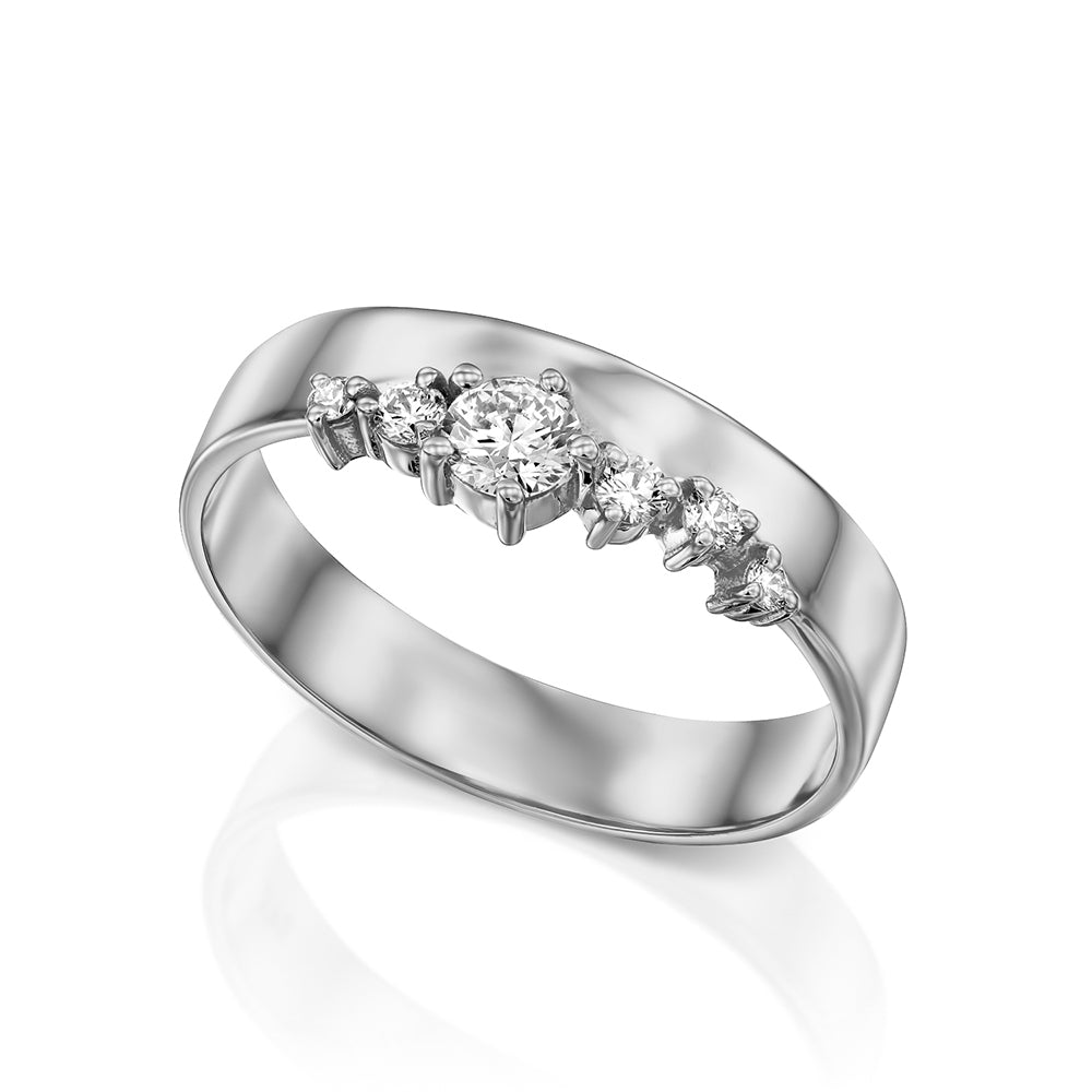 A wide gold ring with a special asymmetric setting of diamonds