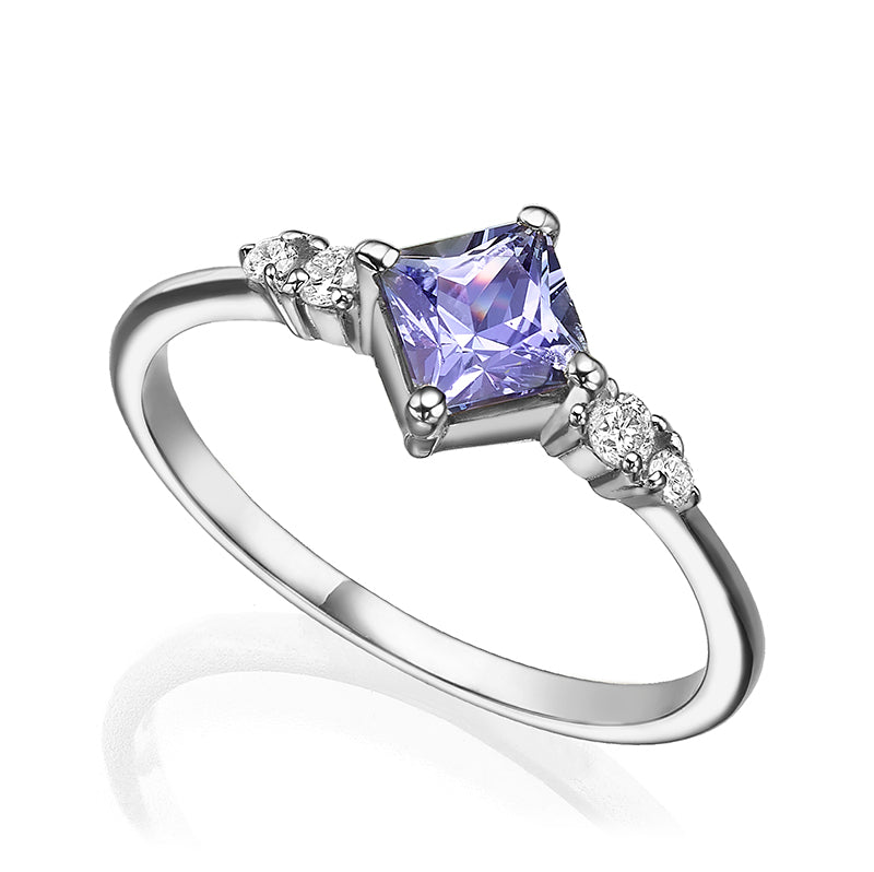 A gold ring set with princess-cut tanzanite and diamonds on the sides