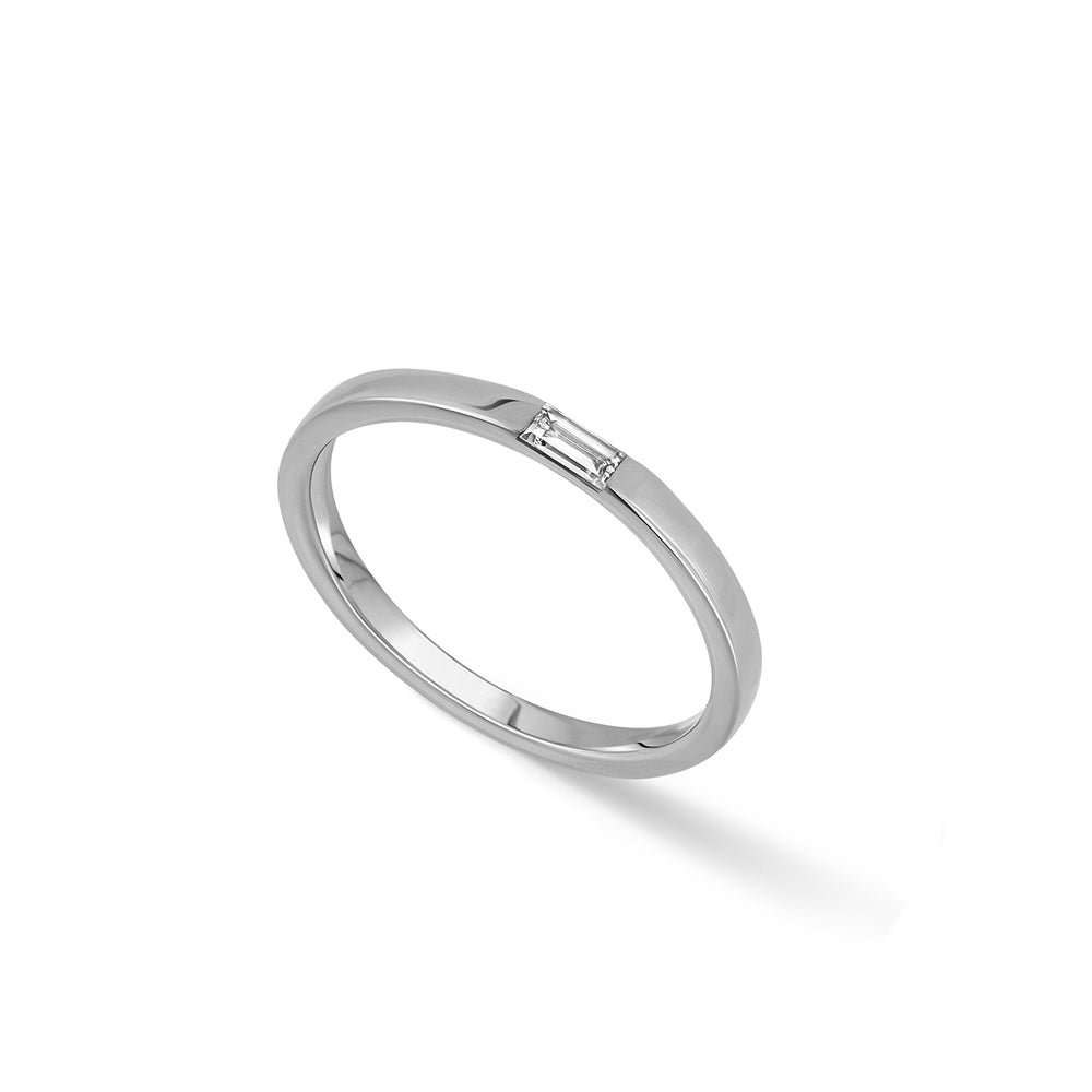 A thin flat gold ring set with a baguette-cut laboratory diamond
