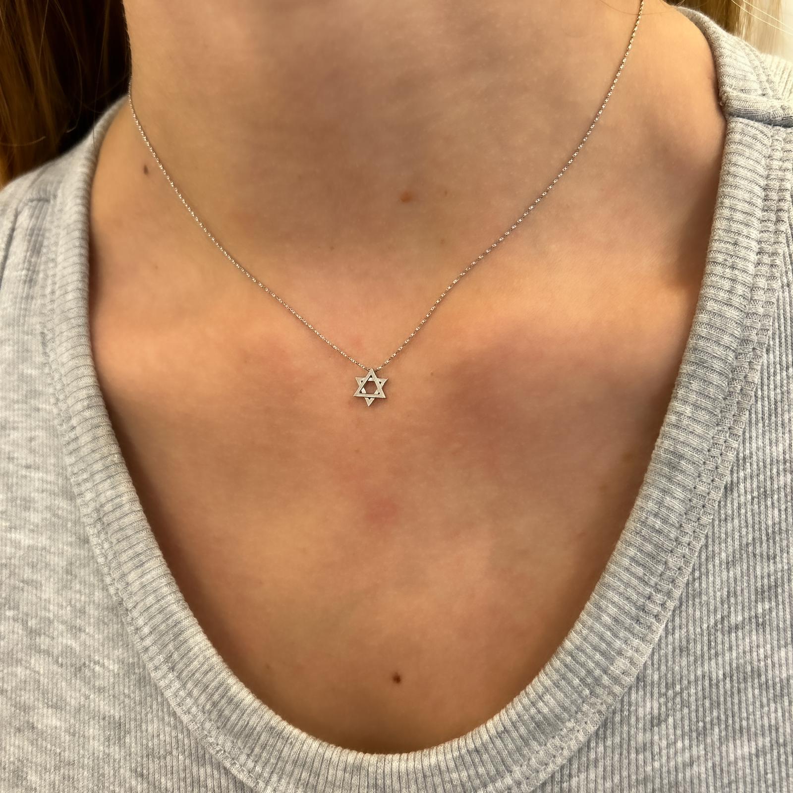 A gold chain with a small gold Star of David pendant threaded onto a gold chain