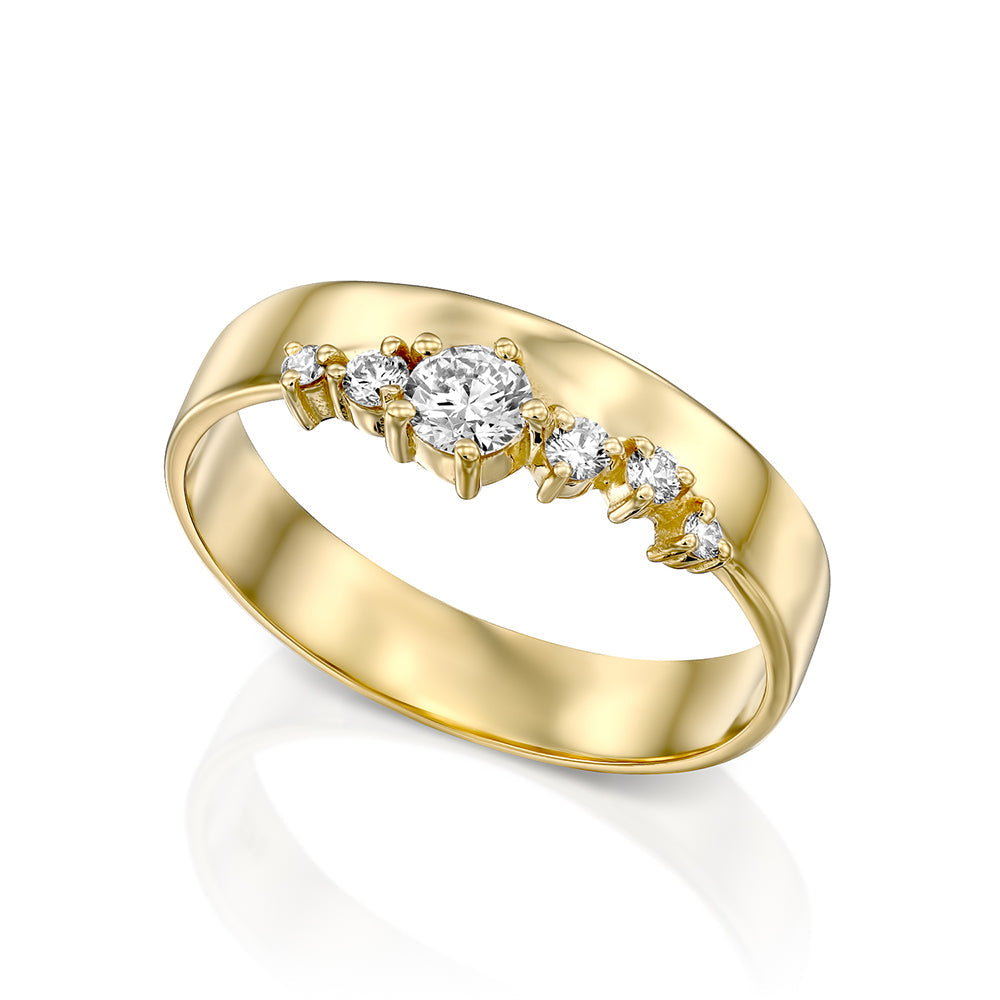 A wide gold ring with a special asymmetric setting of diamonds