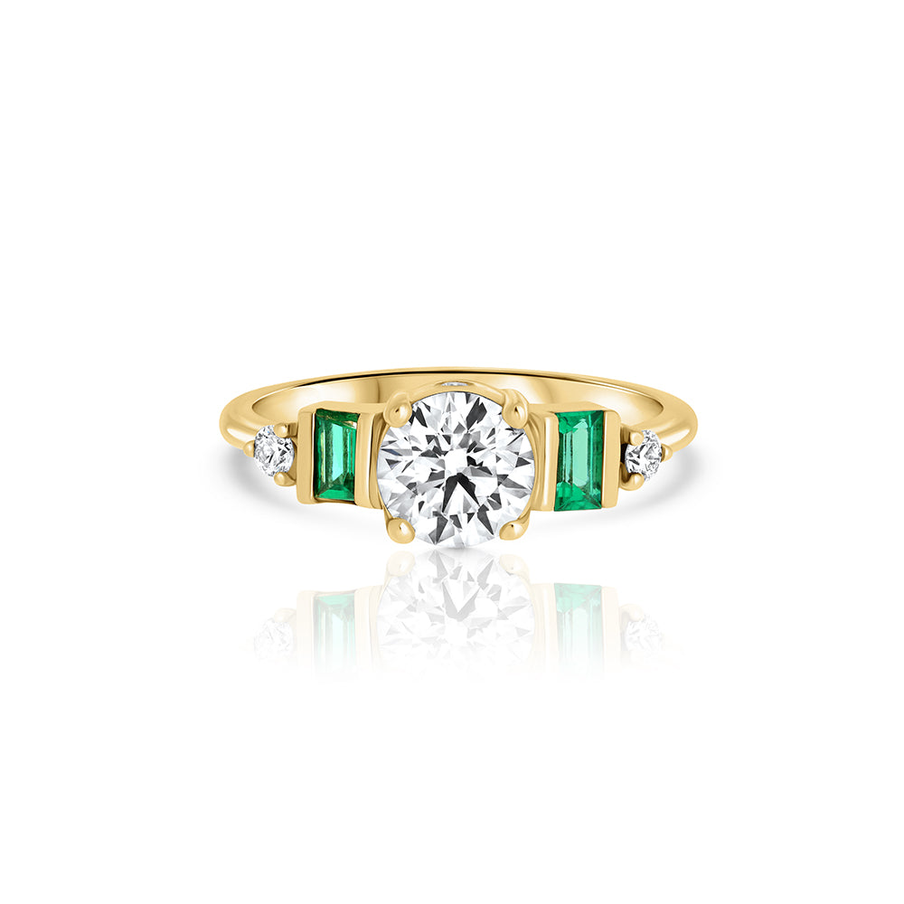An engagement ring in gold and laboratory diamonds in a unique design of round diamonds and emeralds
